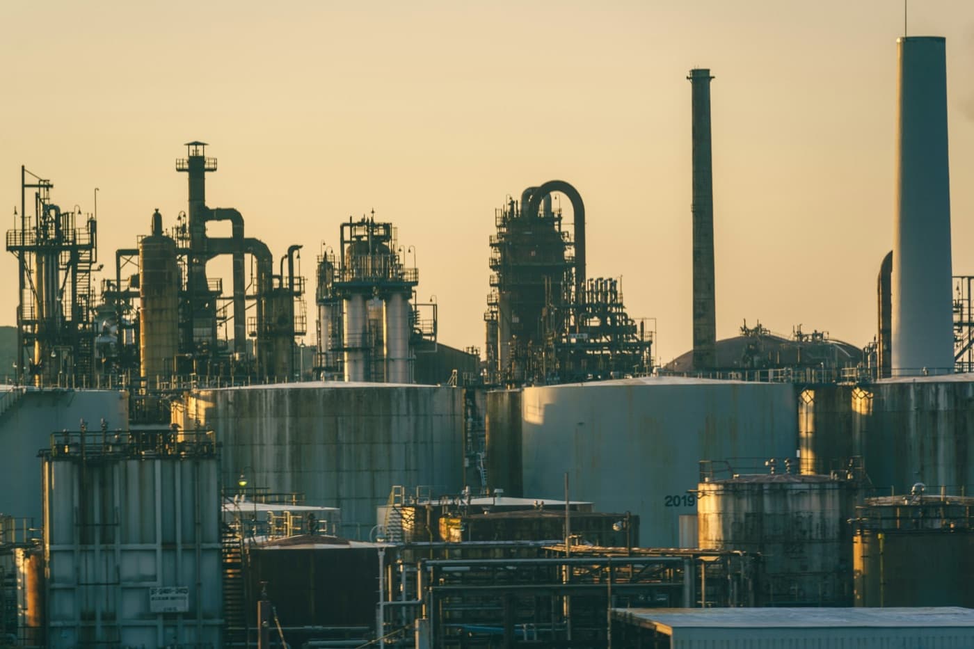 Oil refinery with storage tanks at golden hour